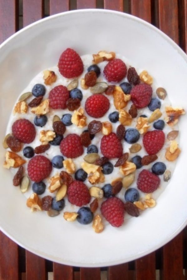 An image of Delicious Fruity Porridge with raspberries, blueberries, walnuts and honey.