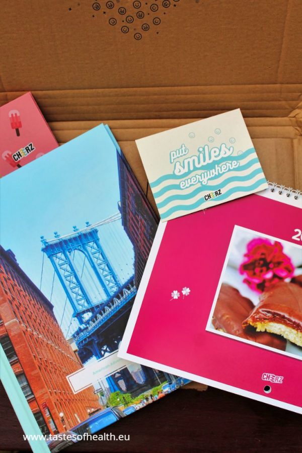 A picture taken from above of a pink calendar and a photobook with holiday pictures.