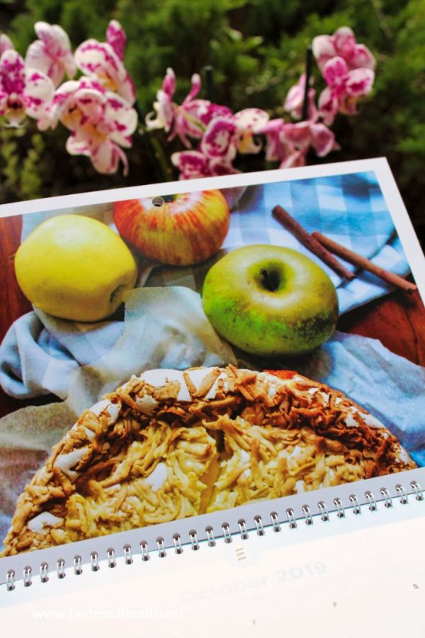 An image of a personalised calendar with a photo of a cake and 3 apples.